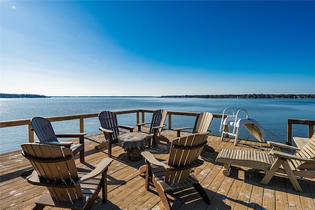 view of dock with a water view and a fire pit