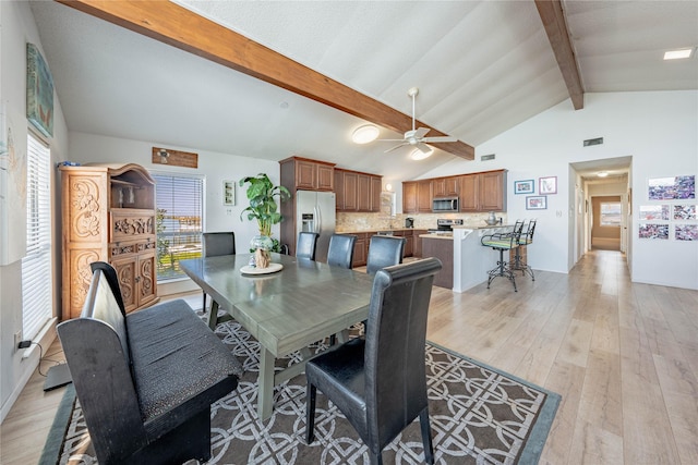 dining room featuring beam ceiling, light hardwood / wood-style flooring, high vaulted ceiling, and ceiling fan