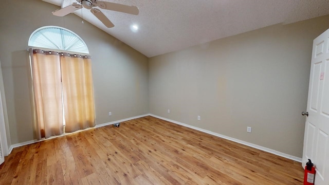 empty room with light hardwood / wood-style floors, a textured ceiling, ceiling fan, and vaulted ceiling