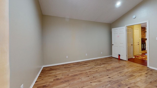 unfurnished bedroom with light hardwood / wood-style floors and vaulted ceiling