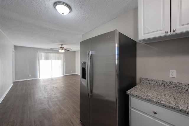 kitchen featuring ceiling fan, stainless steel fridge with ice dispenser, light stone counters, a textured ceiling, and white cabinets