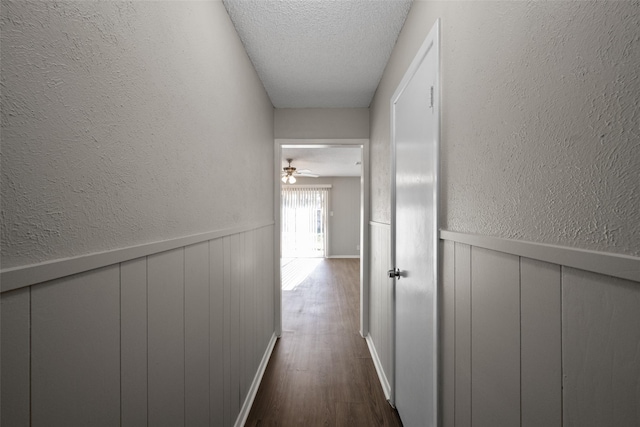 hall featuring dark hardwood / wood-style floors and a textured ceiling