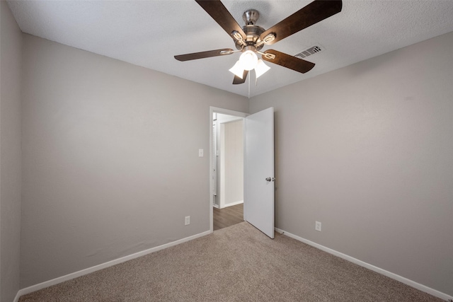 carpeted spare room featuring ceiling fan