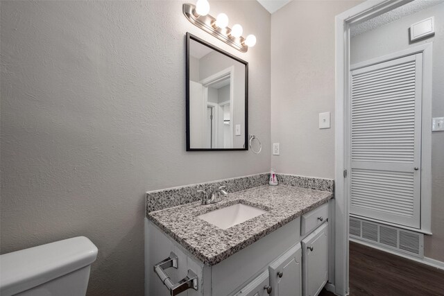 bathroom featuring hardwood / wood-style floors, vanity, and toilet