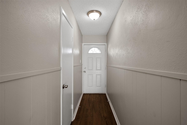 entryway featuring a textured ceiling and dark wood-type flooring