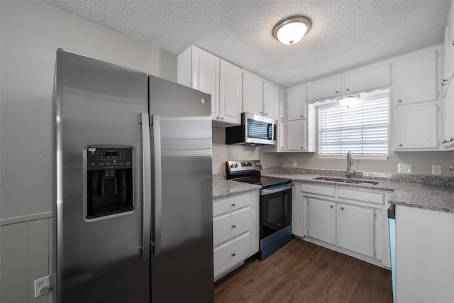 kitchen featuring dark hardwood / wood-style flooring, sink, white cabinets, and appliances with stainless steel finishes