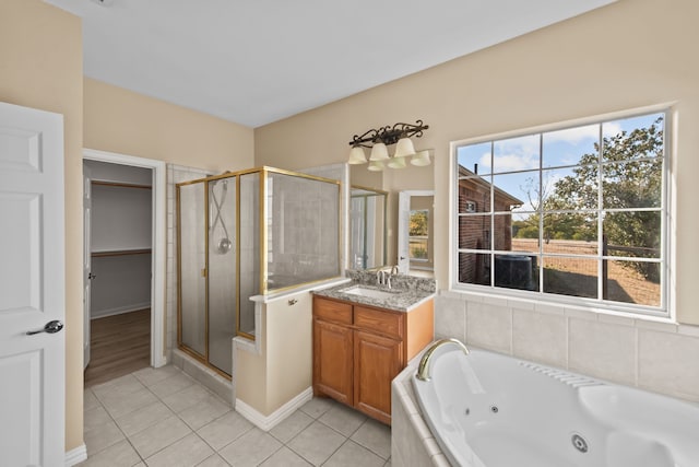 bathroom featuring plus walk in shower, tile patterned flooring, and vanity