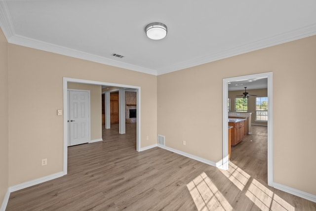 spare room with ceiling fan, ornamental molding, and light hardwood / wood-style flooring