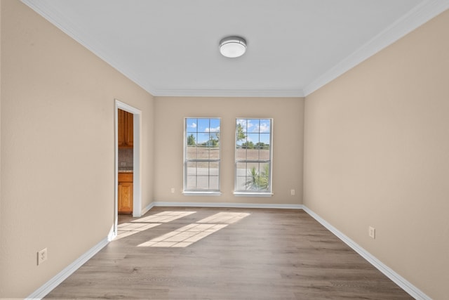 empty room featuring crown molding and light wood-type flooring