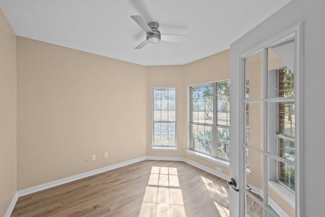 empty room featuring ceiling fan, plenty of natural light, and light hardwood / wood-style flooring