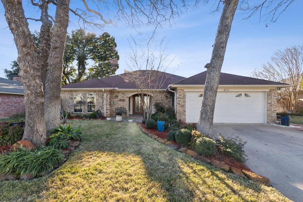 ranch-style home with a front yard and a garage