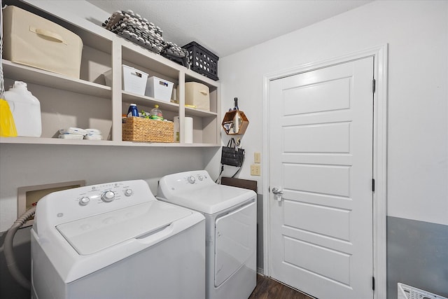 clothes washing area featuring washing machine and dryer and dark hardwood / wood-style flooring