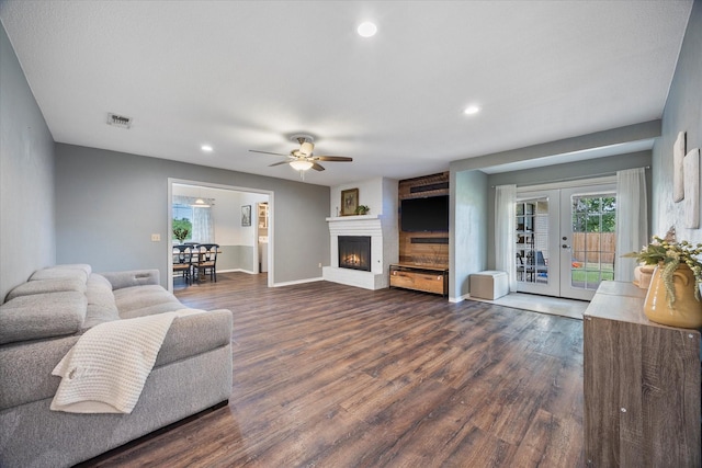 living room with dark wood-type flooring, ceiling fan, and french doors