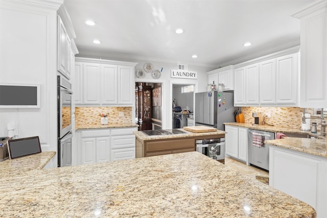 kitchen featuring ornamental molding, white cabinetry, stainless steel appliances, and tasteful backsplash