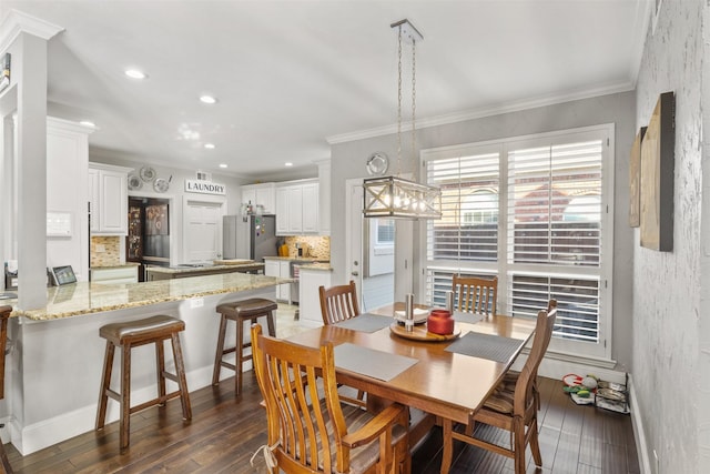 dining space featuring dark hardwood / wood-style flooring and ornamental molding