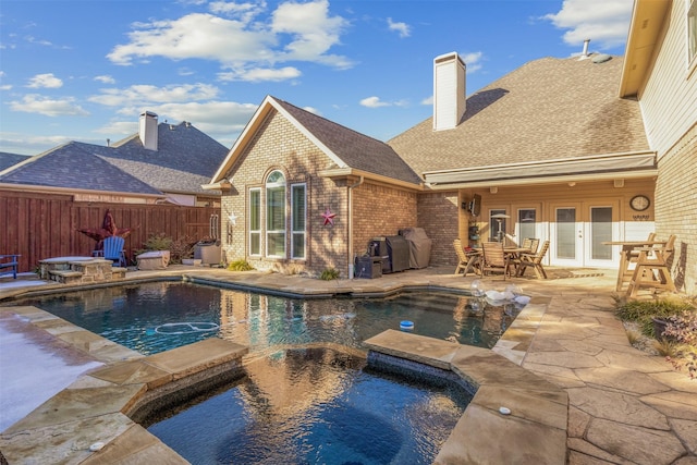 view of swimming pool featuring a patio area, an in ground hot tub, and french doors