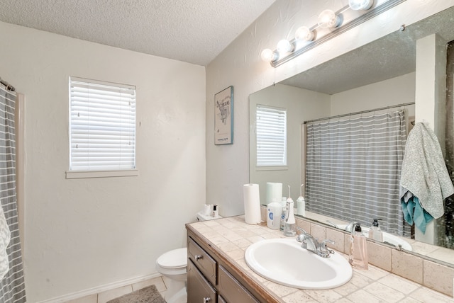 bathroom with vanity, a wealth of natural light, toilet, and a textured ceiling