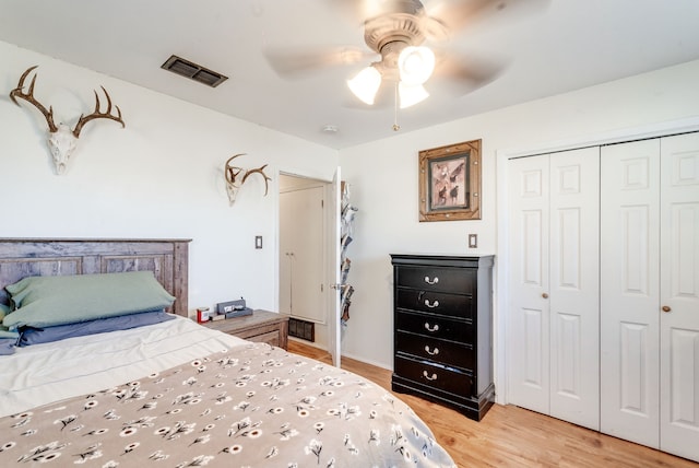 bedroom with light hardwood / wood-style flooring, ceiling fan, and a closet