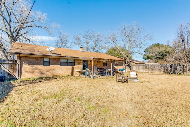 rear view of property featuring a yard and a patio area