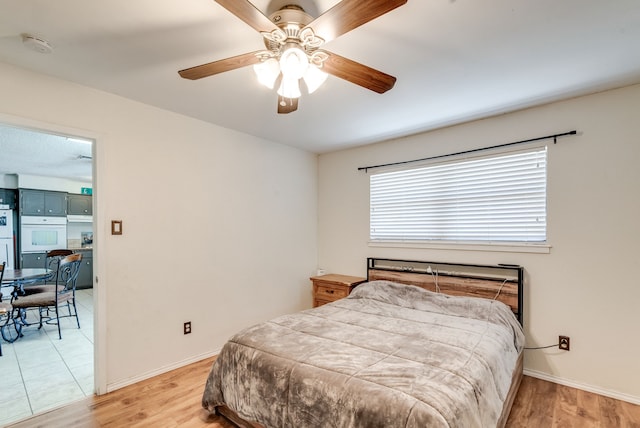 bedroom with ceiling fan and light hardwood / wood-style flooring