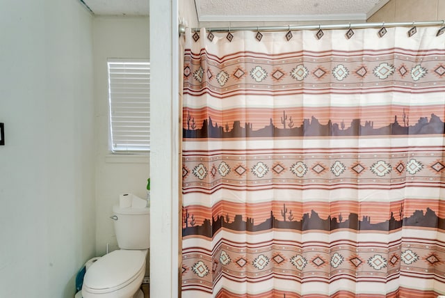 bathroom with a textured ceiling, curtained shower, ornamental molding, and toilet