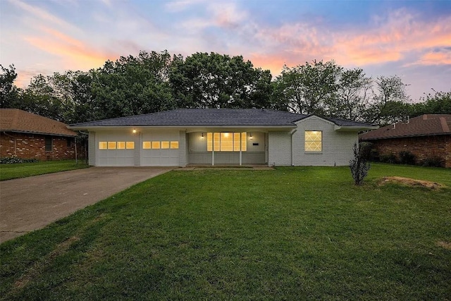 ranch-style home featuring a lawn and a garage