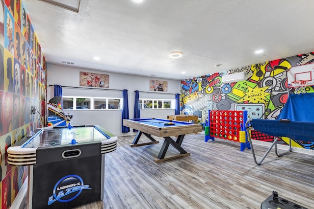 recreation room with wood-type flooring, pool table, and a textured ceiling