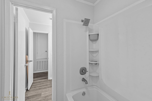 bathroom featuring ornamental molding, hardwood / wood-style floors, and  shower combination