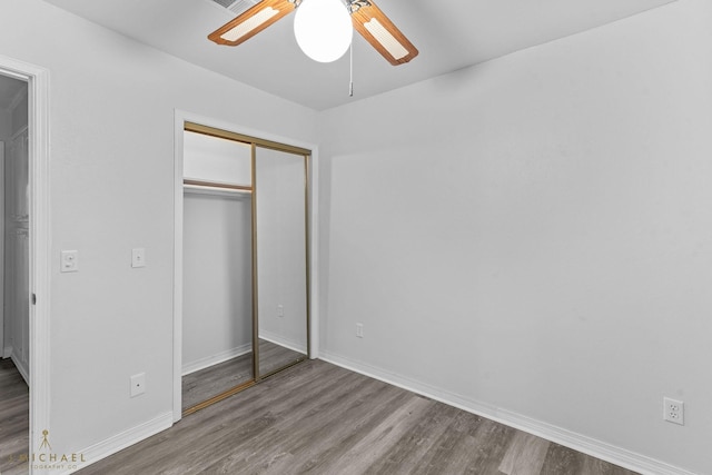 unfurnished bedroom featuring wood-type flooring, a closet, and ceiling fan