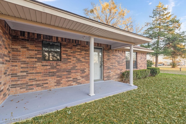 view of exterior entry with a yard