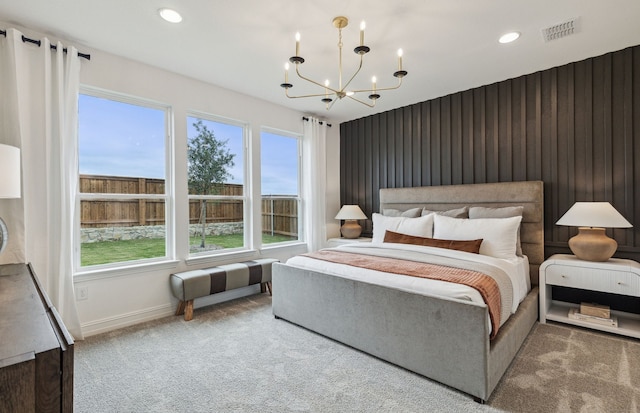 carpeted bedroom with wooden walls and a chandelier