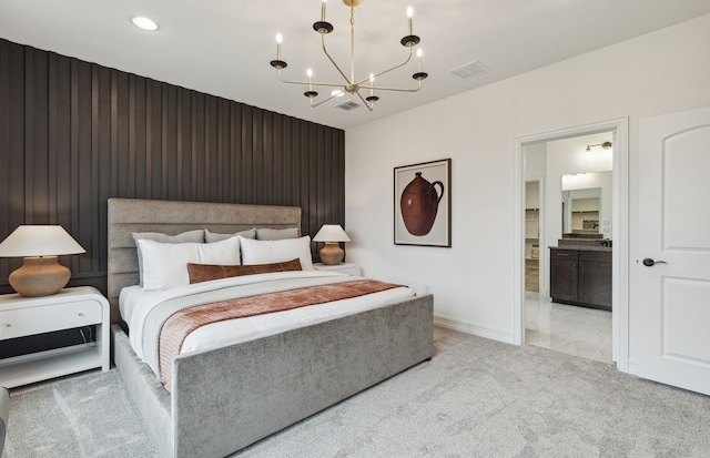 carpeted bedroom with ensuite bathroom and a chandelier