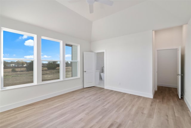 spare room with vaulted ceiling, ceiling fan, and light wood-type flooring