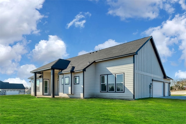 back of house with a garage and a lawn