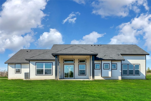 rear view of property with a lawn and cooling unit