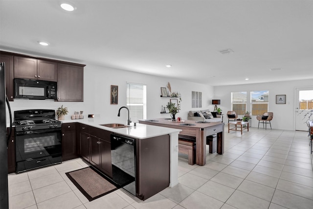 kitchen with black appliances, sink, dark brown cabinetry, light tile patterned floors, and kitchen peninsula