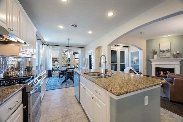 kitchen featuring sink, light stone countertops, an island with sink, white cabinetry, and stainless steel appliances