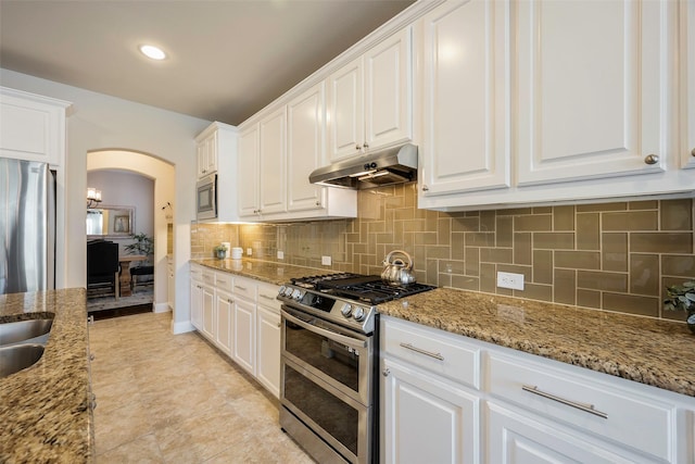 kitchen featuring backsplash, light stone counters, white cabinets, and stainless steel appliances