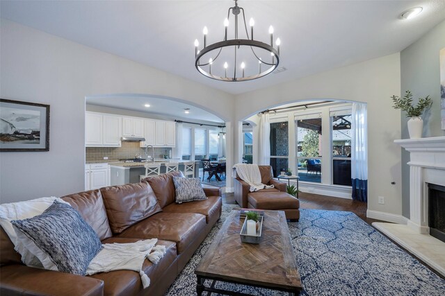 living room with light wood-type flooring, sink, and a chandelier