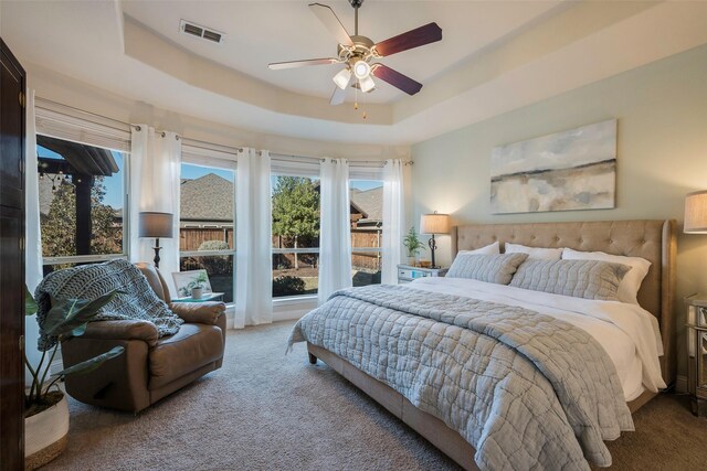 bedroom featuring a tray ceiling, ceiling fan, and carpet floors