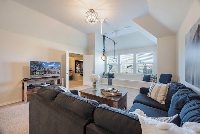 carpeted living room with a chandelier and vaulted ceiling