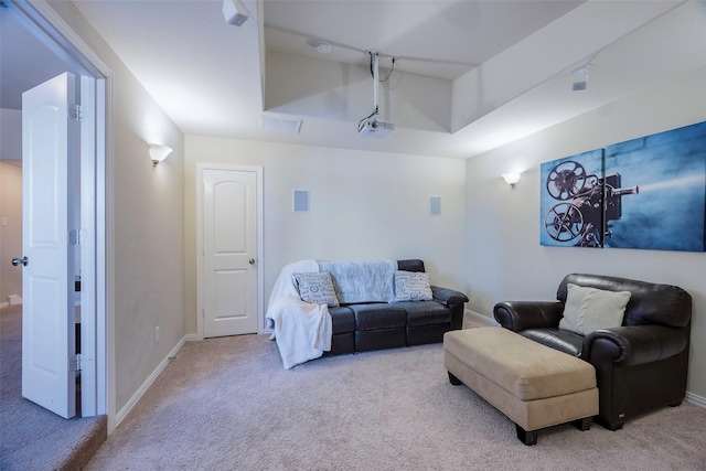 living room featuring a raised ceiling and light colored carpet