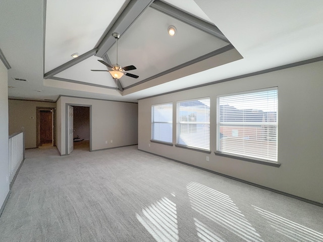 interior space with ceiling fan, ornamental molding, plenty of natural light, and a tray ceiling