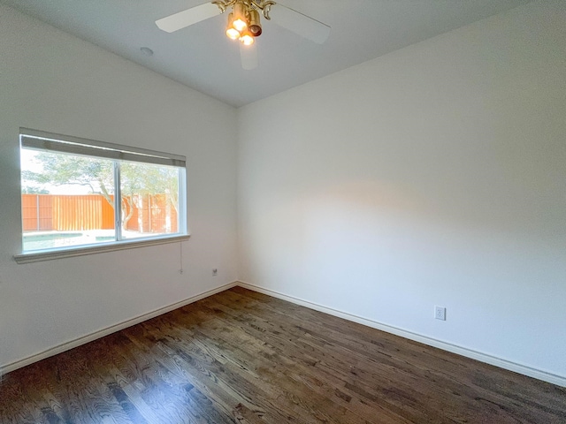 empty room with vaulted ceiling, ceiling fan, and dark hardwood / wood-style flooring