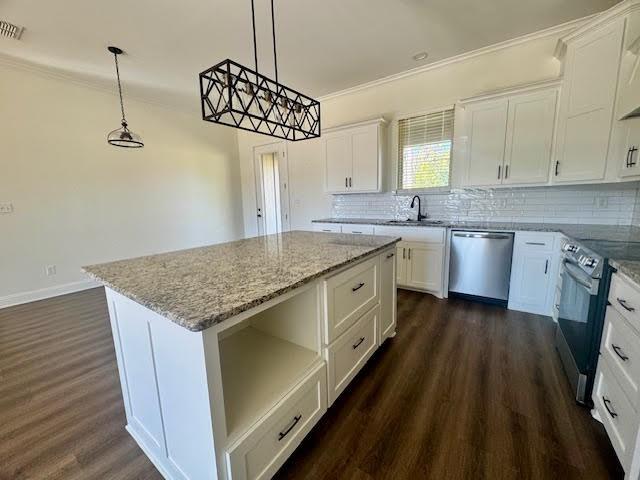 kitchen with decorative light fixtures, a center island, stainless steel appliances, and white cabinetry