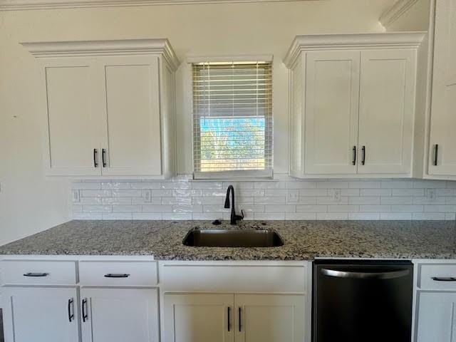 kitchen featuring sink, white cabinets, stainless steel dishwasher, and stone countertops