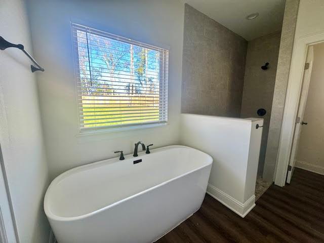 bathroom featuring hardwood / wood-style flooring and independent shower and bath