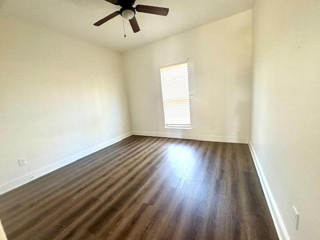 spare room with ceiling fan and dark hardwood / wood-style flooring