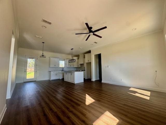 unfurnished living room featuring dark hardwood / wood-style floors, ceiling fan, and crown molding