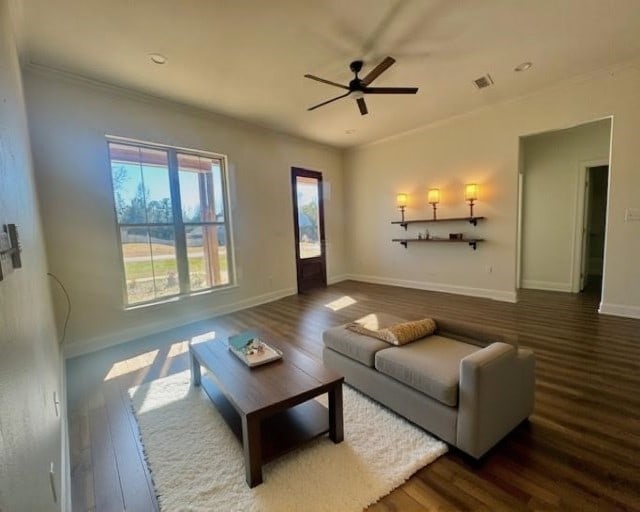 living room featuring ornamental molding, ceiling fan, and dark wood-type flooring